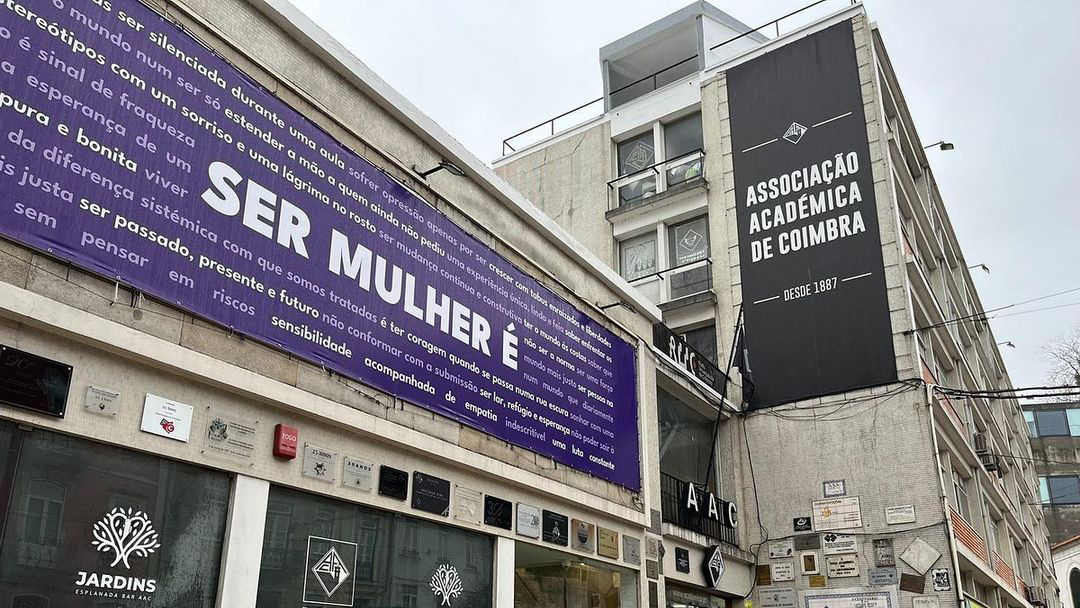 Picture of Associação Académica de Coimbra's building facade, with a large purple banner for the Women's Day.