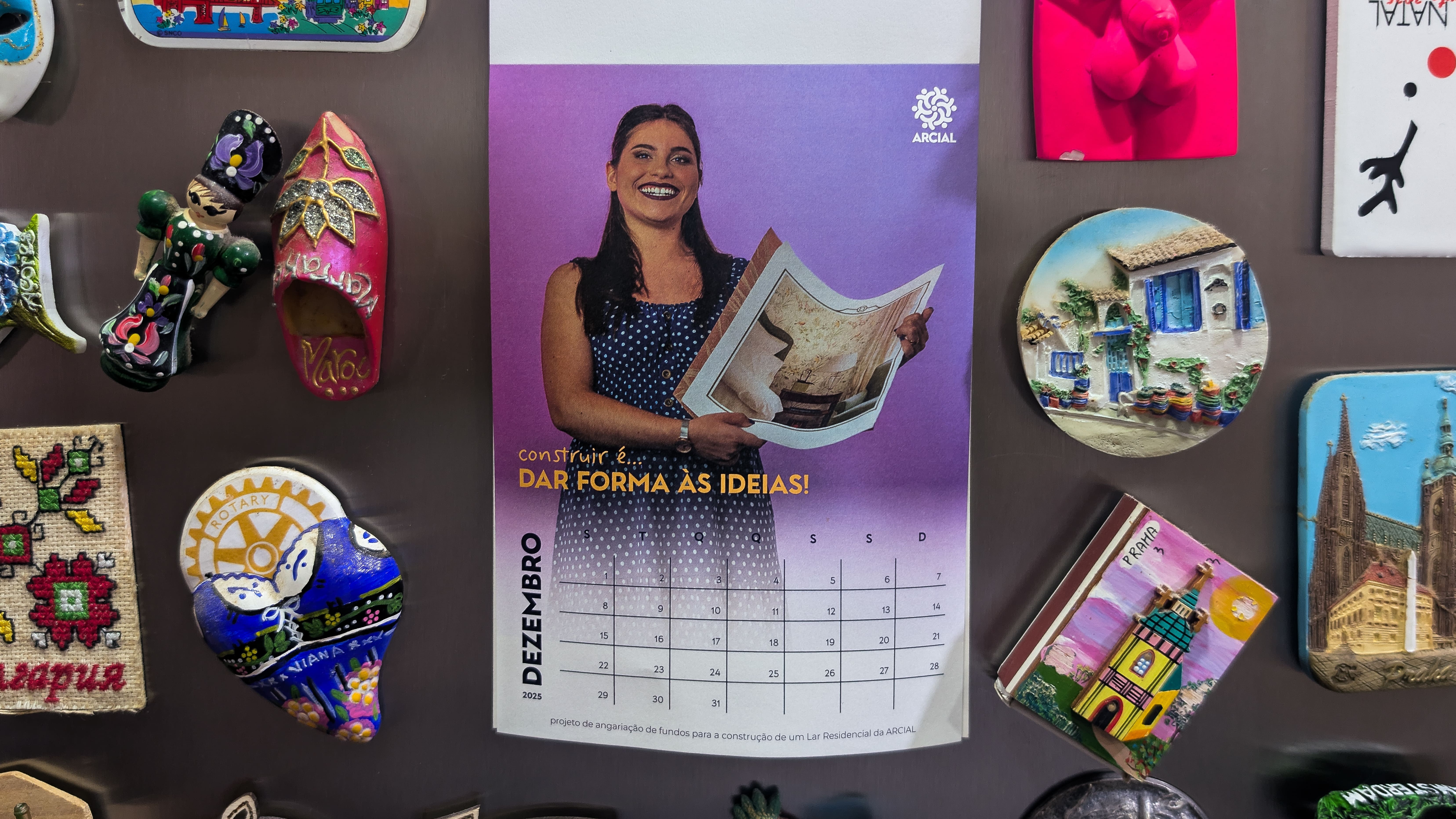 Picture for the December page of Casa de Sorrisos calendar, on a fridge filled with magnets.