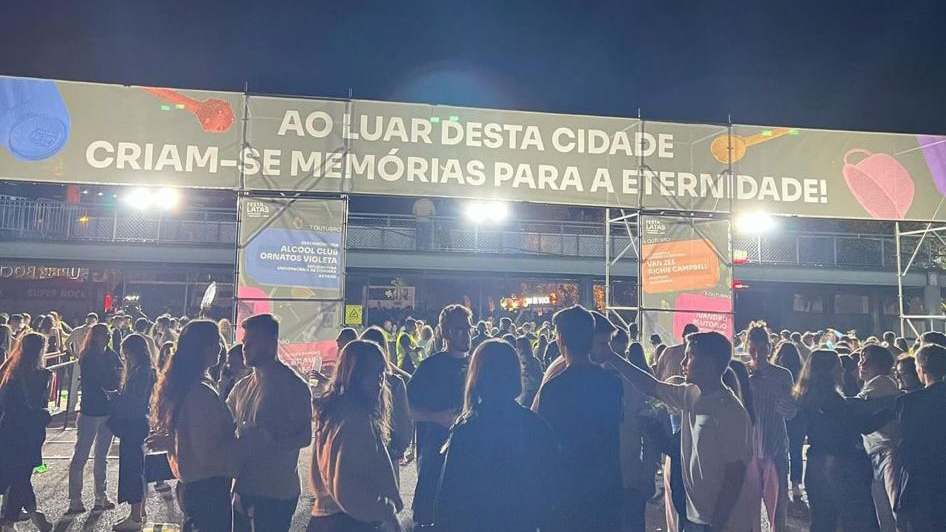 Picture of Festa das Latas's venue entrance, with a crowd in front of it, and a large banner over the entrance with graphic elements of the festival's visual identity.