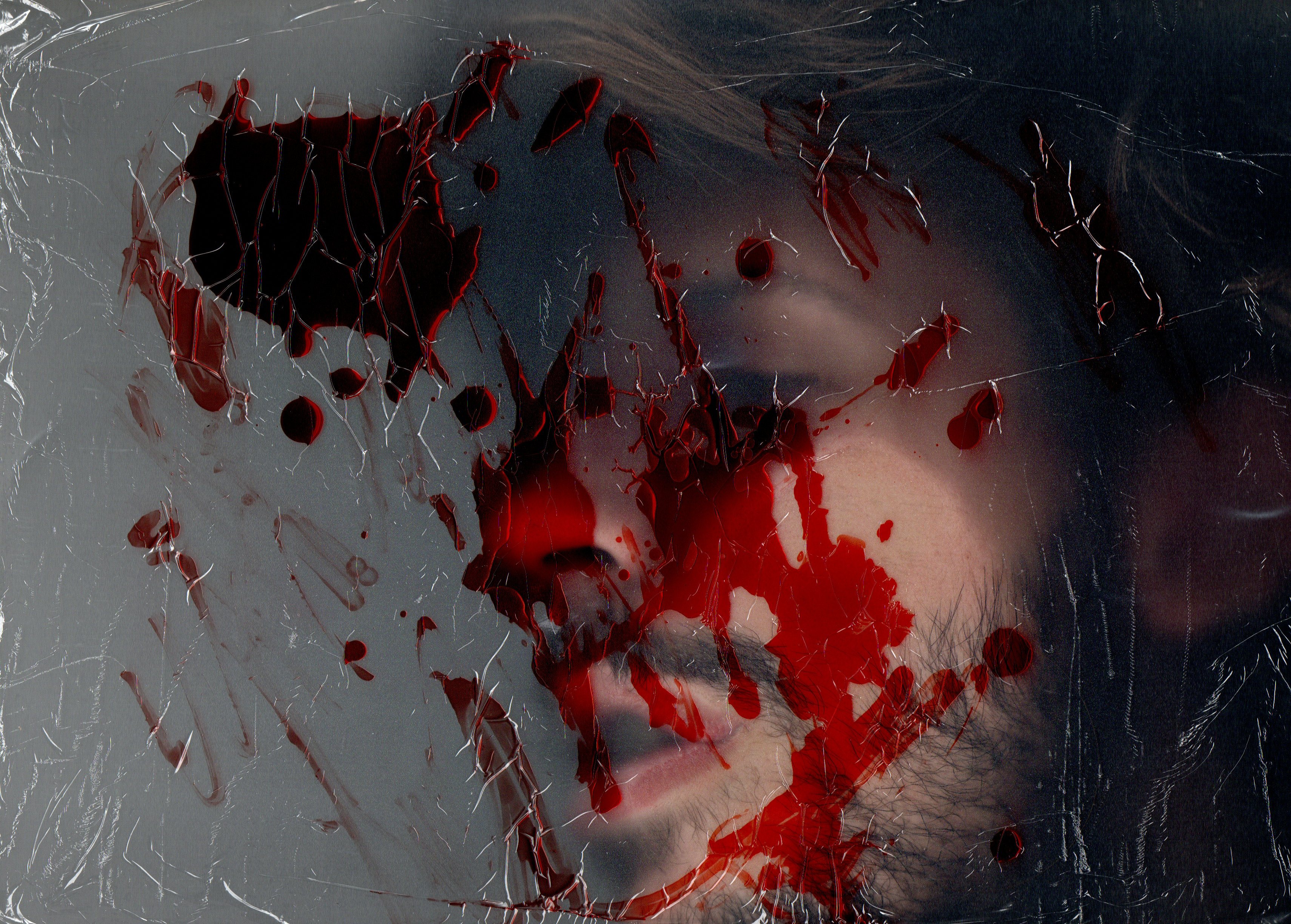 Scanned image of a face with blood scattered around it.